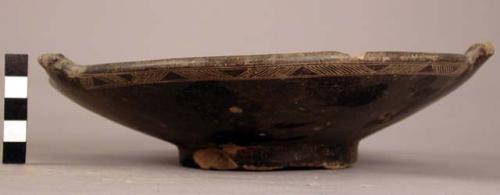 Pottery plate - black with fine incising on parts of outside of rim; ring base b