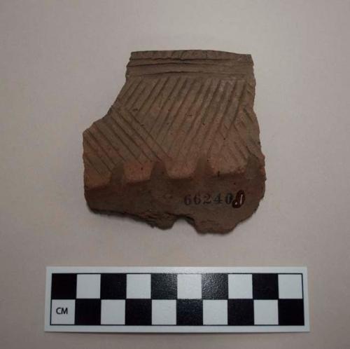 Ceramic, rim sherd, raised features and incised designs