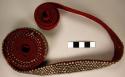 Red woven tape (103" x 1") with silver (alloy) bead-like decoration - used to wr