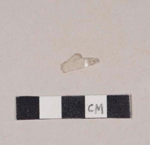 Colorless plastic fragment, stamped with "HT="