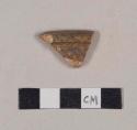 Slip decorated, lead glazed redware rim sherd