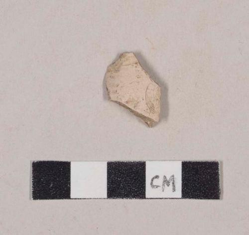 Unsmoked pipe bowl fragment with incised line around rim and possible stamped cartouche