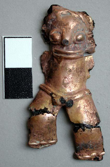 Metal figurine, fragmentary, mounted on yellowed plastic