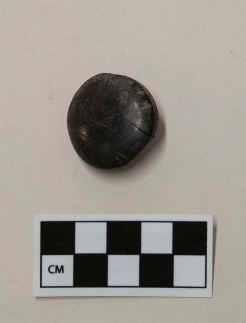 Button-like object made of hard black material