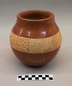 Red-on-buff incised ceramic vase: band of geometric motifs