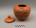 Black-on-red jar (A) with lid (B): stylized parrot motif