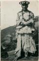 Man standing and holding a bundle. Postcard from G. Nicholson to C. C. Willoughby.