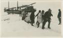 Arctic Voyage of Schooner Polar Bear - Crew pulling supplies from schooner overland