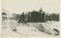 Arctic Voyage of Schooner Polar Bear - Two men and dogs standing outside log cabin