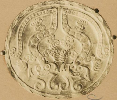 Disk with abstract face design, possibly made of gold