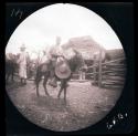 People and donkeys in front of stables