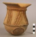 Unpainted pottery tripod jar - legs missing, relief and incised decoration