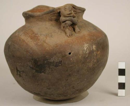 Pottery jar, handles connected with lip, plastic work and rudely carved to