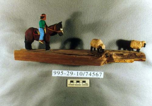 Carved scene of horseback rider and two sheep