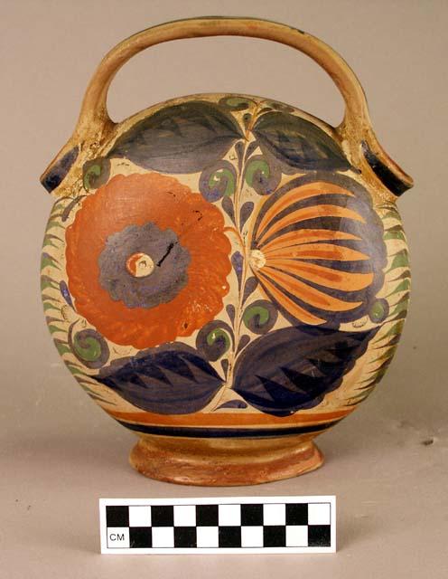 Stirrup pot.  Painted polychrome; floral pattern on tan background.