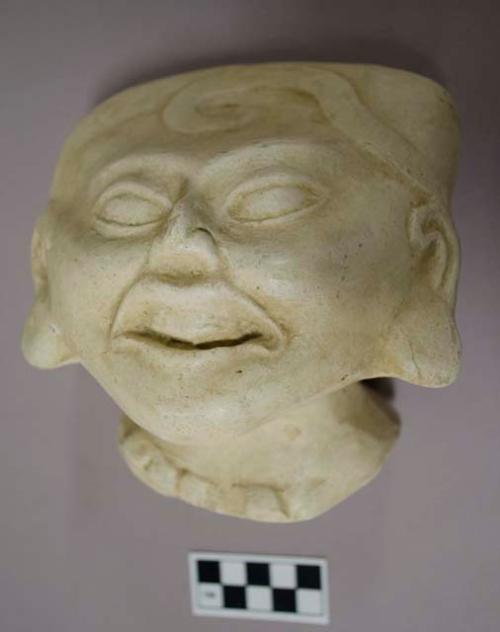 Cast of "laughing face"- scroll design in bas relief on forehead