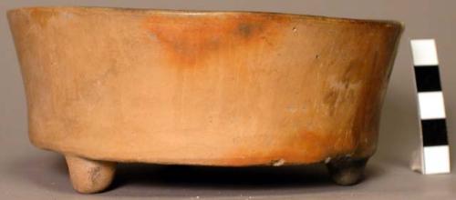 Tan low-sided flat-bottomed tripod bowl of pottery-two clay pellets in bottom