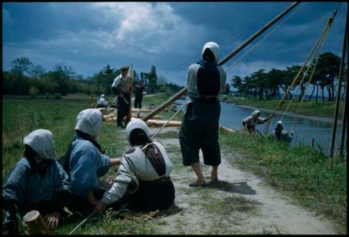 Women pulling ropes on pile driver