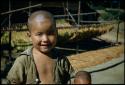 Child sitting in front of tobacco drying