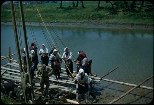 Women raising pole with ropes