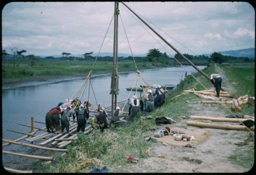 Women raising pole with ropes