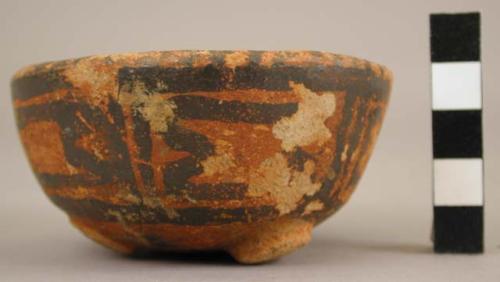Small red bowl with black manganese paint; lacks legs.
