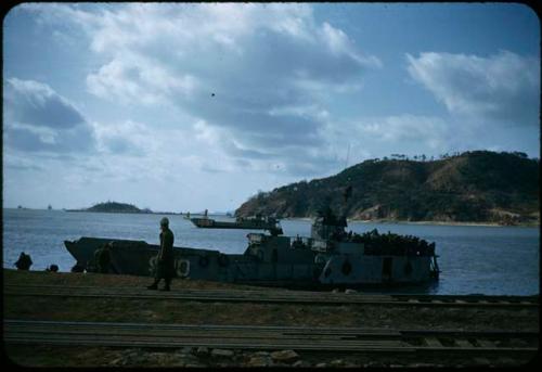 Railroad tracks and boat along shore