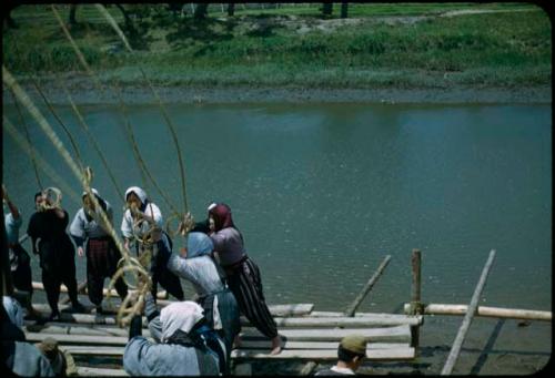 Women raising pole with ropes