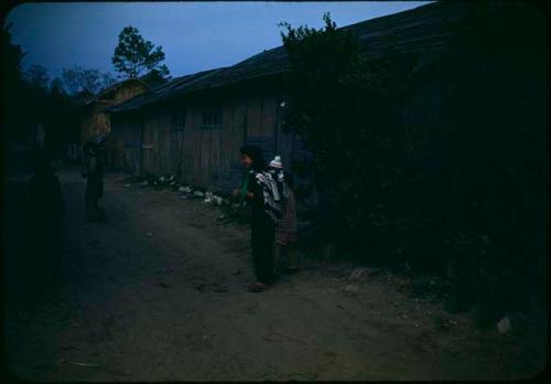 Woman with baby in front of house