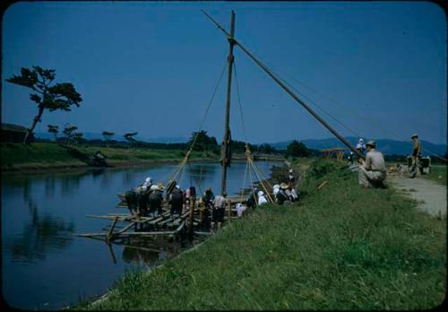 Group raising a pole with ropes