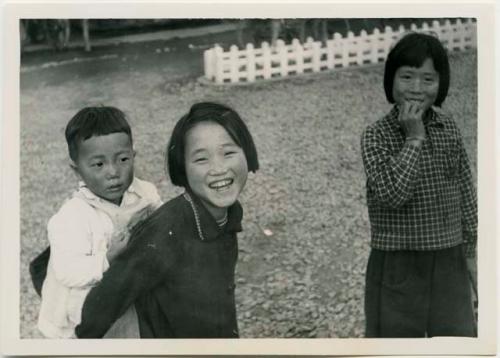 Girl carrying younger brother on her back