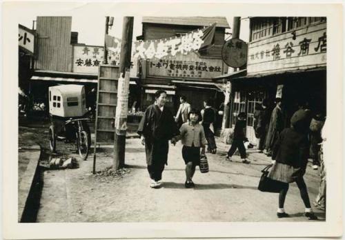 Woman and girl walking down street