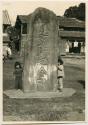 Children and stone monument with Shimenawa or sacred rope