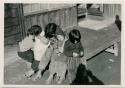 Group of children in front of house