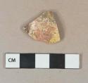 Yellow and brown slip decorated redware vessel body fragment,  heavily degraded