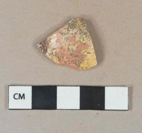 Yellow and brown slip decorated redware vessel body fragment,  heavily degraded