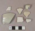White salt-glazed stoneware vessel rim fragments, 1 body fragment, 2 fragments molded with "barley" pattern, 1 with floral molded decoration, light gray paste