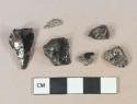 Unburned coal fragments; 1 unidentified black glass fragment