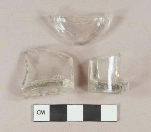 Colorless glass vessel base fragments, all fragments crossmend, likely bottle base