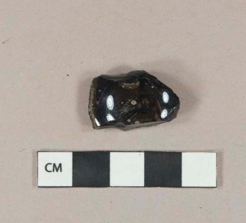 Dark amber vessel glass base fragment, likely bottle fragment