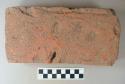 Intact red brick, fingerprints on one side