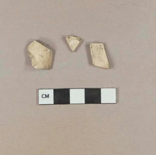 Two unsmoked, undecorated pipe bowl fragments; one smoked, undecorated pipe bowl fragment