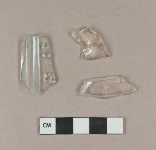 Colorless bottle glass fragments; embossed aqua bottle glass fragment