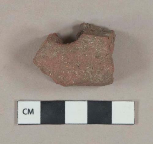Red ceramic roof tile fragment, part of hole