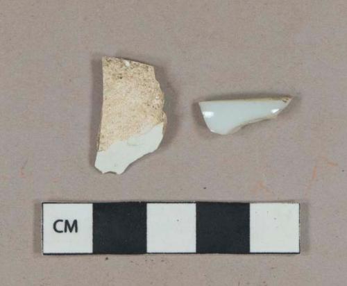 White undecorated porcelain vessel rim fragment, ground edge; White undecorated pearlware vessel body fragment, white paste