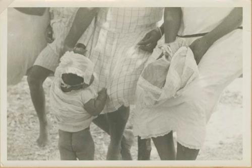 Toddler being helped to stand