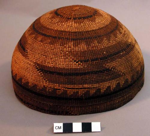 Woman's basketry cap with tan and black geometric designs on exterior