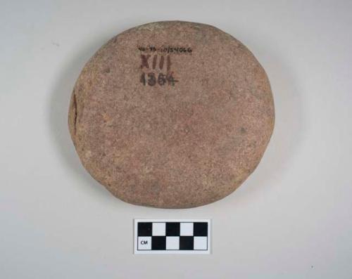 Possible palette. discoidal cobble. 1 slightly concave face has a red pigment st