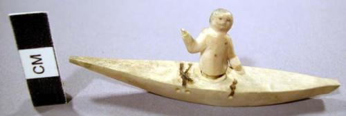 Ivory earring of Eskimo kayak and hunter