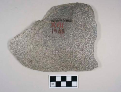 Possible stone implement, tabular slab, possibly thinned by flaking, along part
